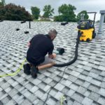 Man cleaning dryer vent in Latrobe PA roof