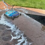 Cleaning and preparing stamped and dyed concrete for application of gloss color enhancing sealer.
